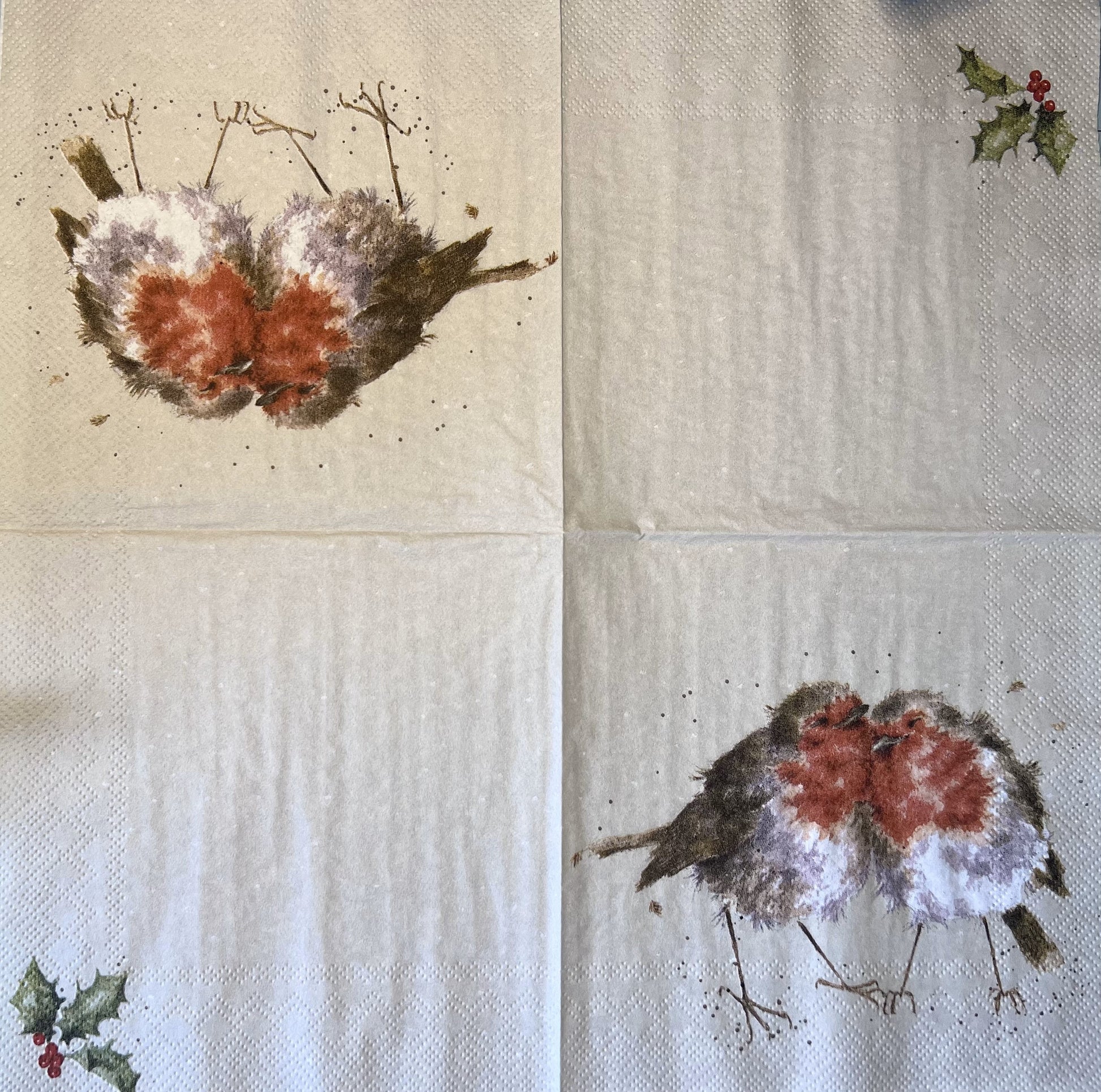 this watercolor illustration on this napkin shows the open napkin with two robins on two quadrants and a little holly leaves in the corner of the other two quadrants (etsy image id: 4803897426)