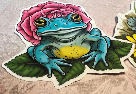 bright blue color Frog atop greenery and pink rose in the background (etsy image id: 6646218546)