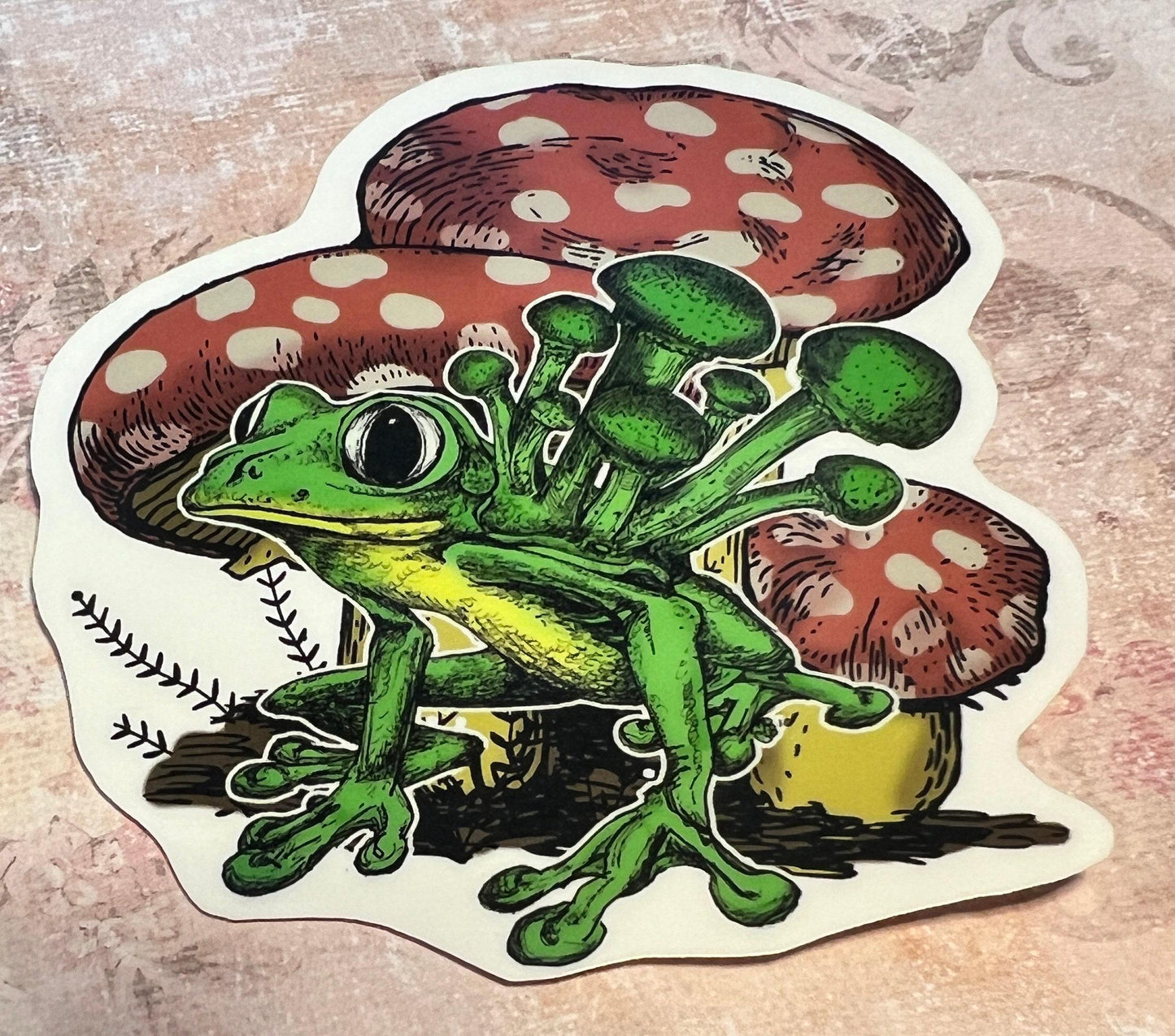 Green and yellow color Frog atop greenery and  red and white spotted mushrooms int he background with mushrooms magically growing on the back of the frog (etsy image id: 6646218644)