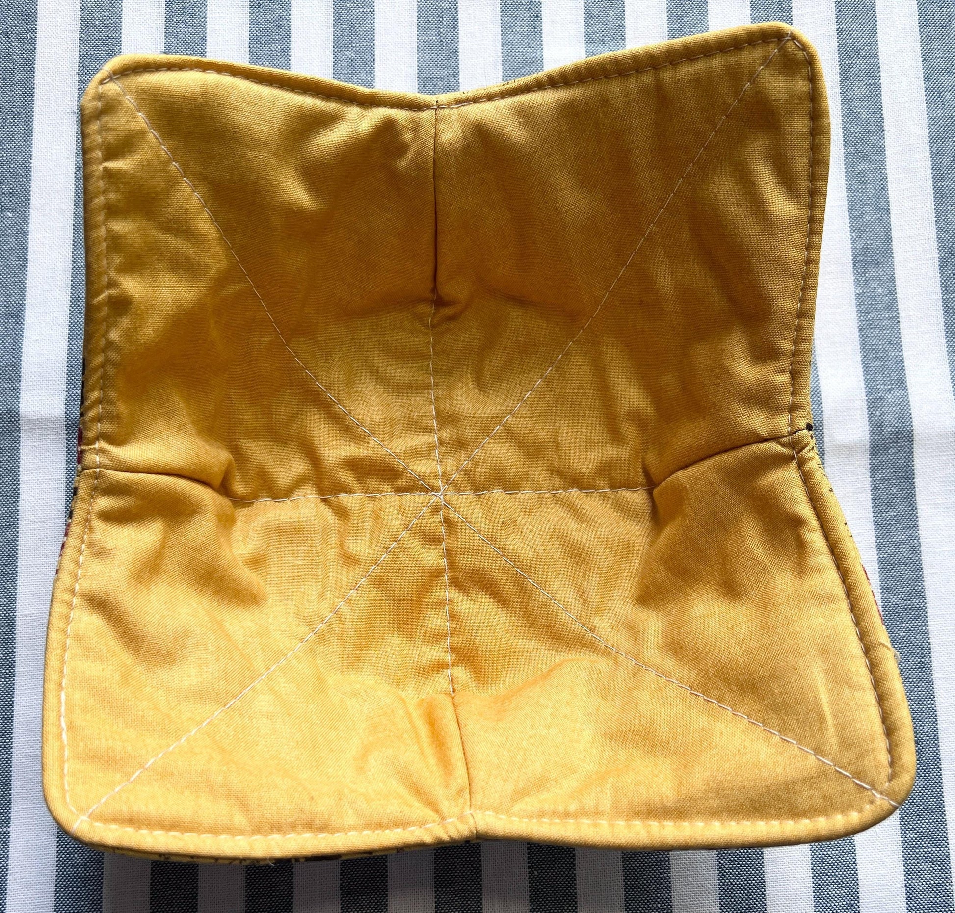 Shows one of a golden yellow solid color bowl cozy for holding your hot soup bowl. (etsy image id: 6723713888)