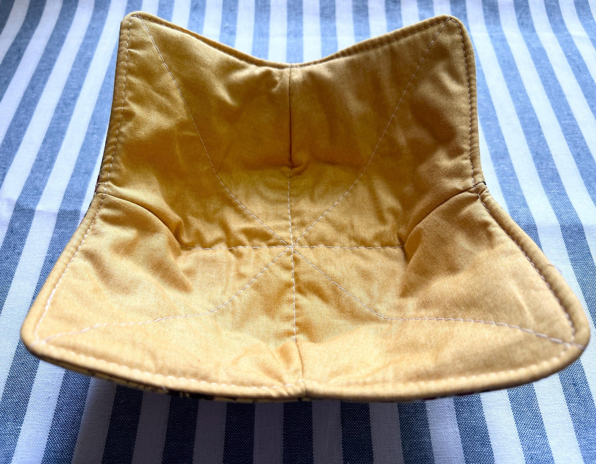 Shows a side of a golden yellow  bowl cozy for holding your hot soup bowl. (etsy image id: 6771742027)